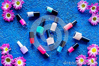 Choose nail polish for manicure. Bottles of colored polish on blue background top view Stock Photo