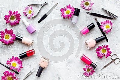 Choose nail polish for manicure. Bottles of colored polish on grey background top view copyspace Stock Photo