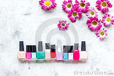 Choose nail polish for manicure. Bottles of colored polish on grey background top view copyspace Stock Photo