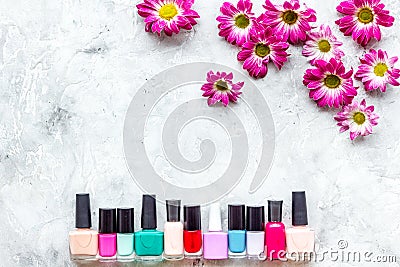 Choose nail polish for manicure. Bottles of colored polish on grey background top view copyspace Stock Photo