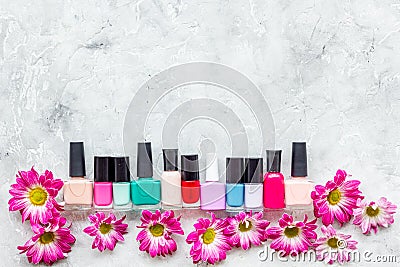 Choose nail polish for manicure. Bottles of colored polish on grey background top view copyspace Stock Photo