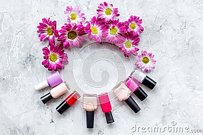 Choose nail polish for manicure. Bottles of colored polish on grey background top view copyspace Stock Photo