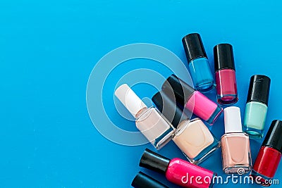 Choose nail polish. Polish bottels on blue background top view copy space Stock Photo