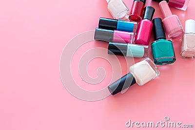 Choose nail polish. Polish bottels on pink background top view copy space Stock Photo