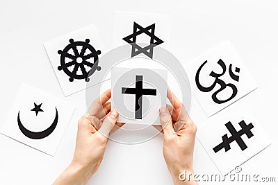 Choose religion concept. Hand with catholic cross near world religions symbols on white background top view Stock Photo