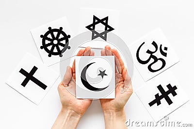 Choose religion concept. Hand with Islam crecent near world religions symbols on white background top view Stock Photo