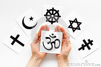 Choose religion concept. Hands with Buddhist Om sign near world religions symbols on white background top view Stock Photo