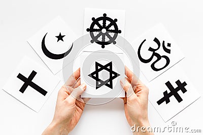 Choose religion concept. Hands with Jewish star of David near world religions symbols on white background top view Stock Photo