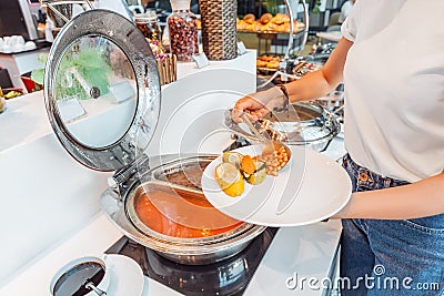 Choosing food in open buffet at breakfast in hotel Stock Photo