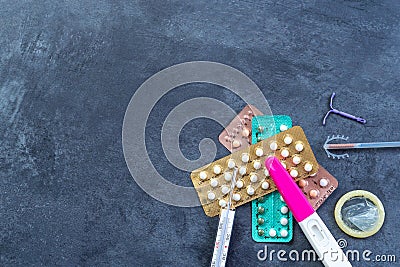 Choosing method of contraception : Birth control pills, an injection syringe, condom, IUD-method, on grey Stock Photo