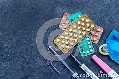 Choosing method of contraception : Birth control pills, an injection syringe, condom, IUD-method, on grey Stock Photo