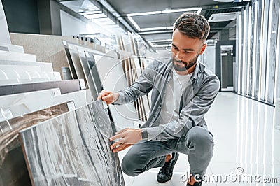 Choosing the plate. Stylish beautiul man is in the store of goods for the home Stock Photo