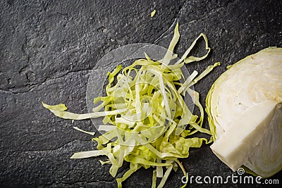 Chopped cabbage on a black stone background. Stock Photo