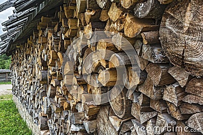 Chopped firewood is packed in a pile of wood under a canopy Stock Photo