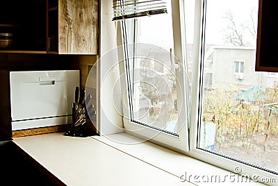 A chopping table with a set of knives in the kitchen against the background of the window. clean workplace for cooking food. Stock Photo