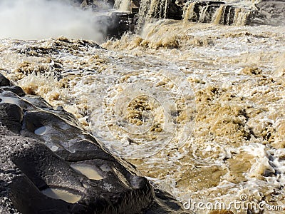 The choppy waters of the Yellow river with eroded rocks Stock Photo