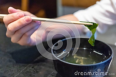 Chopstick holding seaweed from soup Stock Photo