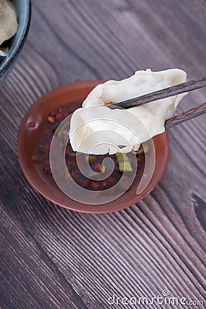 Chopsticks holding dumplings will be dipped in vinegar mixed with water Stock Photo