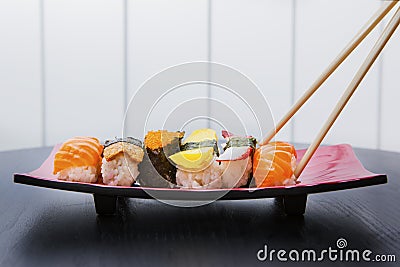 Chopsticks holding a tasty sushi Stock Photo
