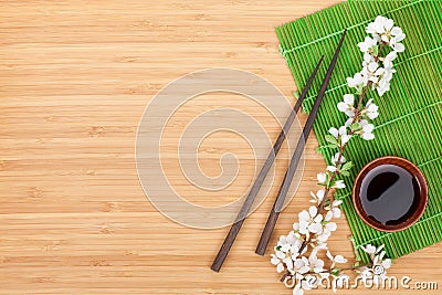 Chopsticks, sakura branch, soy sauce and bamboo mat Stock Photo
