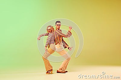 Choreography. Two talented people, autistic man and woman in vintage clothes dancing against gradient green yellow Stock Photo