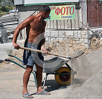 A worker loaded a mixture of a wheelbarrow Editorial Stock Photo