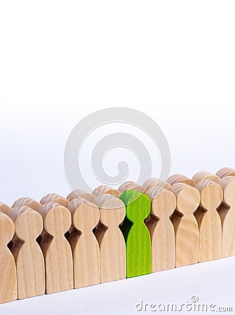 The chosen person among others. A human figure of green color stands in the crowd. Wooden figures of people. A talented worker, a Stock Photo