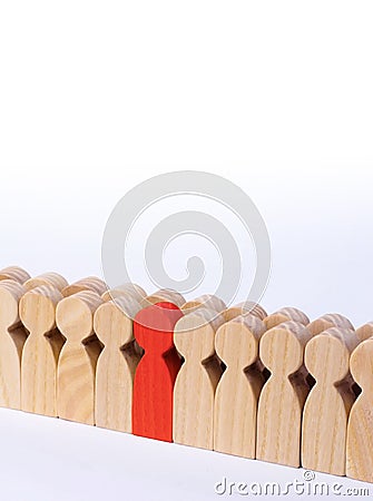 The chosen person among others. A human figure of red color stands in the crowd. Wooden figures of people. A talented worker Stock Photo