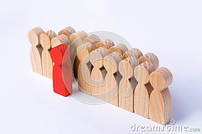 The chosen person among others. A human figure of red color stands out from the crowd. Wooden figures of people. A talented worker Stock Photo