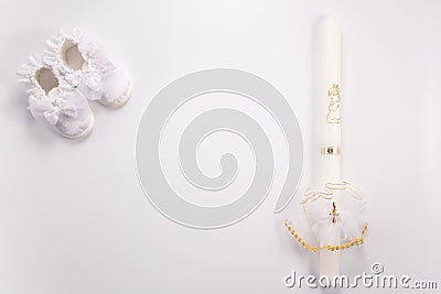 Christening background with baptism baby shoes and candle on white background Stock Photo