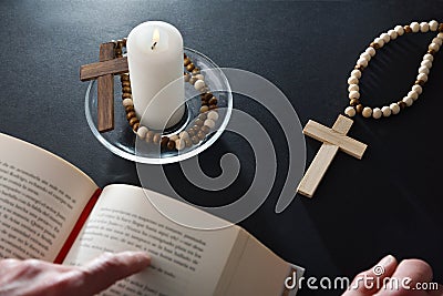 Christian reading the bible on nightstand with religious elements Stock Photo