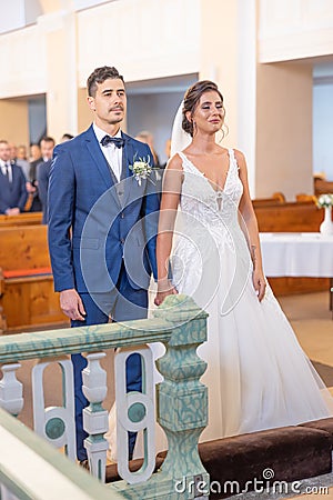 Christian bride and groom stand in front of the altar in the church, getting married Stock Photo