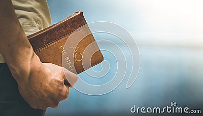 Christian preacher: Young man is holding the bible, praying Stock Photo