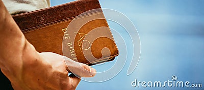 Christian preacher: Young man is holding the bible, praying Stock Photo