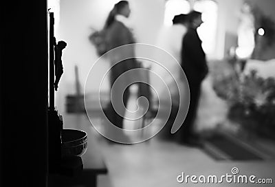 christian wedding couple at catholic church.Focus on Jesus statue Stock Photo