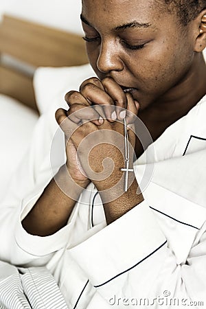 A Christian woman praying in bed Stock Photo