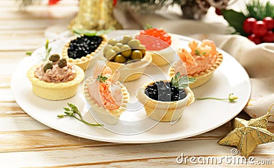 Christmas appetizers. Small tartlets with caviar and pate. Stock Photo