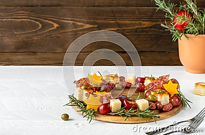 Christmas appetizers wreath on wooden cutting board and rustic wooden background with copy space of text Stock Photo