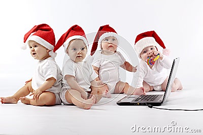 Christmas babies with laptop Stock Photo