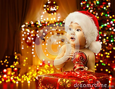 Christmas Baby Opening Present, Happy Kid Santa Hat, Xmas Gift Stock Photo