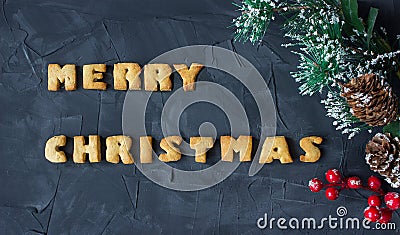 Christmas background with branch of christmas tree with baked gingerbread words merry christmas . creative idea Stock Photo