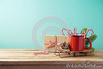 Christmas background with cup on sledges, candy cane and gift bo Stock Photo