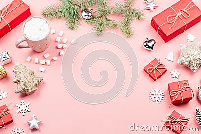 Christmas background with fir branches, lights, red giftboxes, pink decorations, hot drink with snow falling Stock Photo