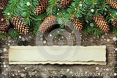 Christmas background of fir tree and conifer cone on old vintage wooden board, fantastic snow effect and aged paper with copy spac Stock Photo