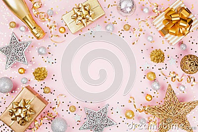 Christmas background with gift or present box, champagne, confetti and holiday decorations on pink pastel table top view. Flat lay Stock Photo