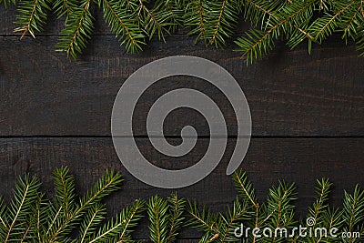 Dark rustic wood table flatlay - Christmas background with green fir tree branch frame. Top view with free space for copy text Stock Photo