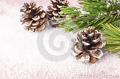 Christmas background, green pine branches, cones decorated with snow on snowy pink background. Creative composition with border Stock Photo