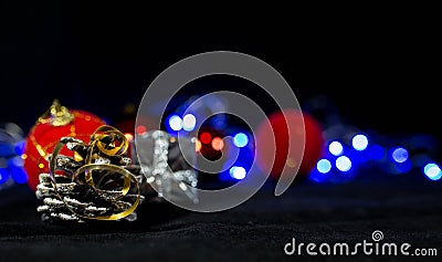 Christmas background image, red balls on the blurred background, blue lights, focus on the pine cone Stock Photo