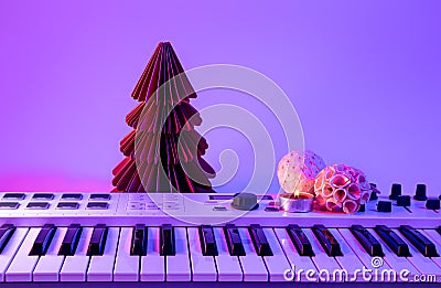 Christmas background with midi keyboard and holiday decor with neon lights. Stock Photo