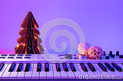 Christmas background with midi keyboard and holiday decor with neon lights. Stock Photo